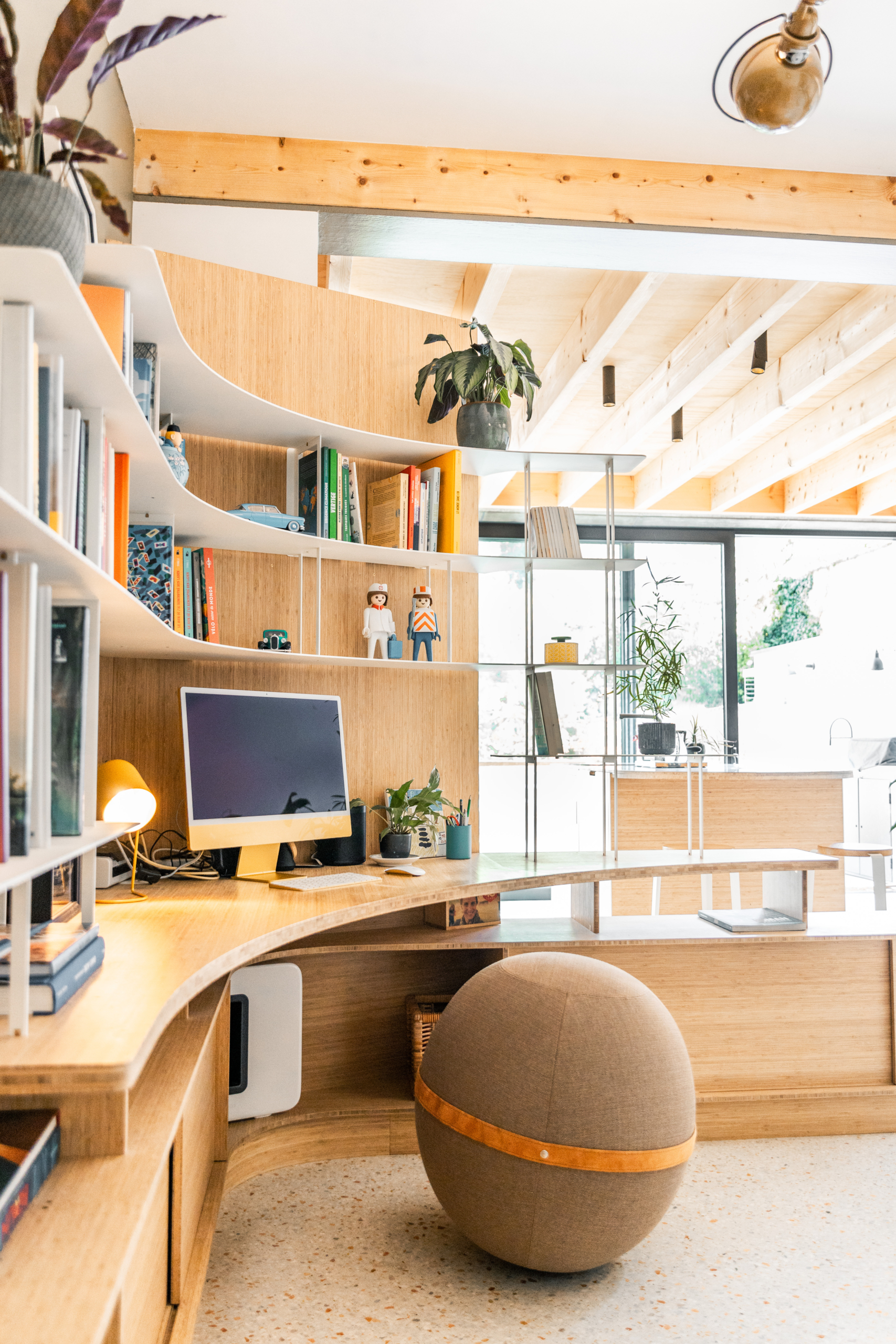 Bureau en coin courbe avec bibliothèque intégrée. Combinaison de bois et acier.