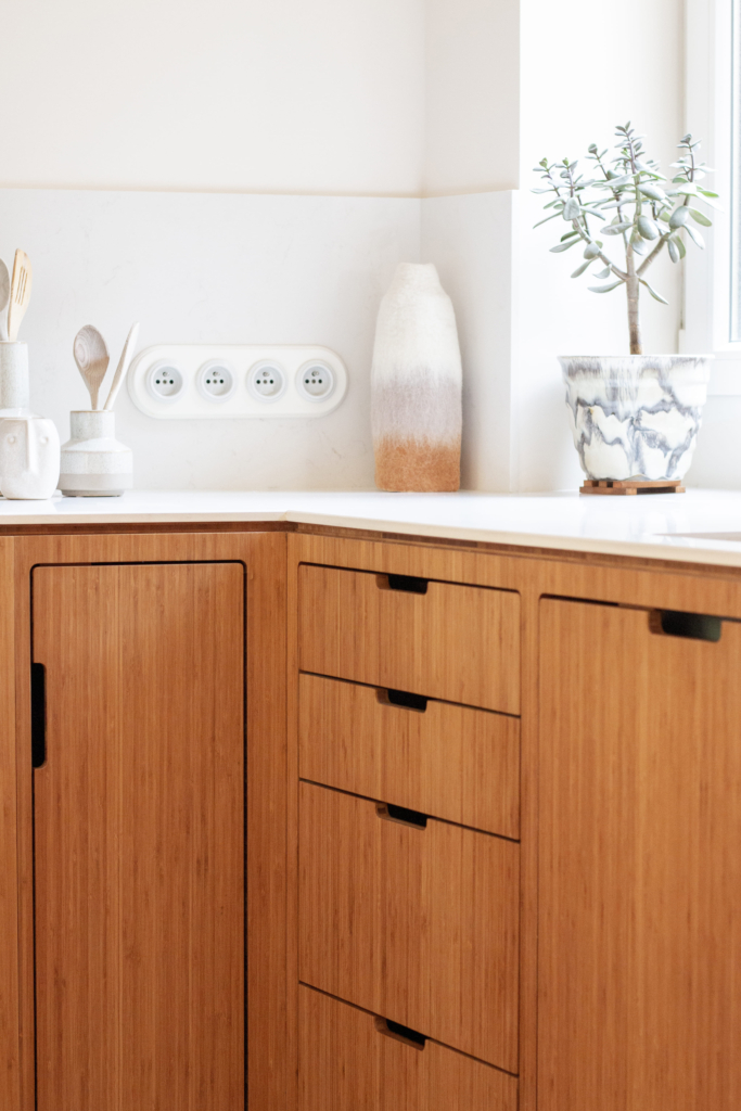 Projet de cuisine en U sur-mesure avec interface buffet pour la salle à manger. Combinaison de bois et pierre blanche.