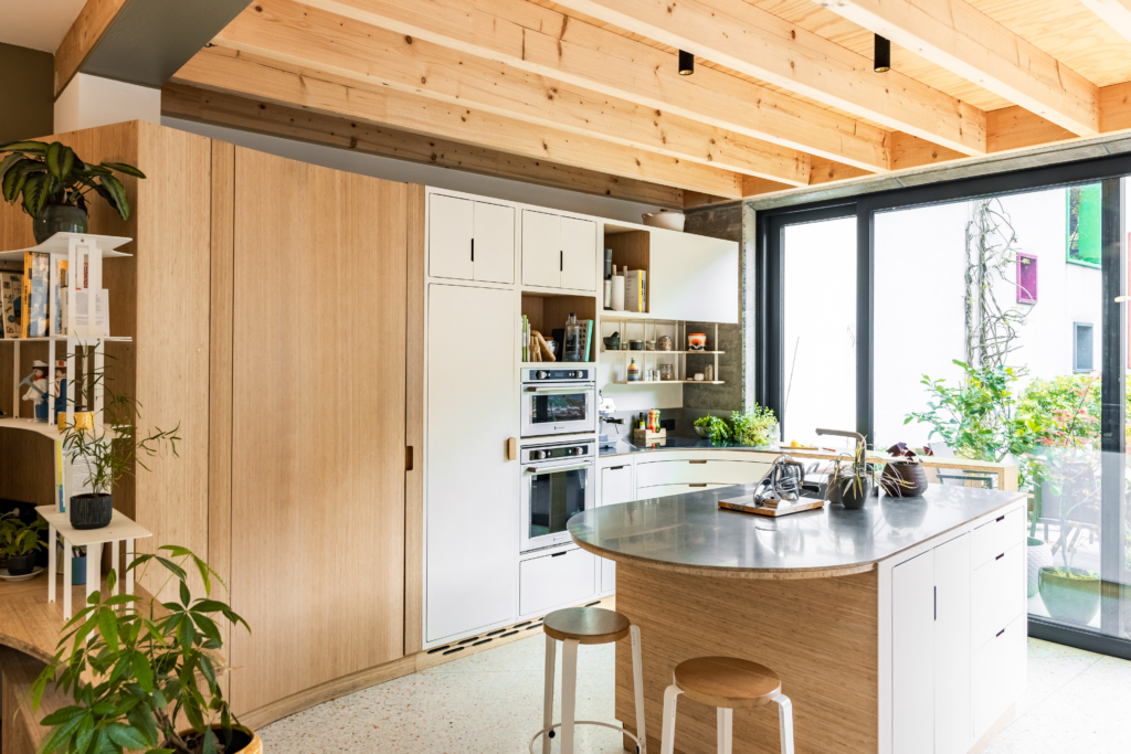 Projet d'architecture d'intérieur pour aménager un rez-de-chaussée. Espace cuisine sur-mesure avec interface vers la salle à manger. Combinaison de bois et acier.